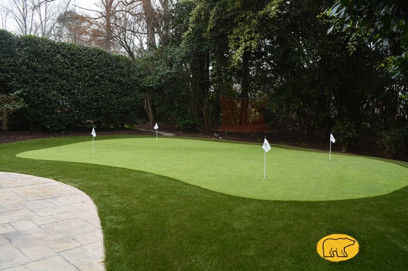 Atlanta Synthetic grass golf green with 4 holes and flags in a landscaped backyard