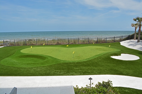 Atlanta Synthetic grass golf green by the sea with yellow flags and a sand bunker