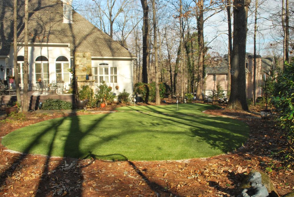 putting green with a house in the background