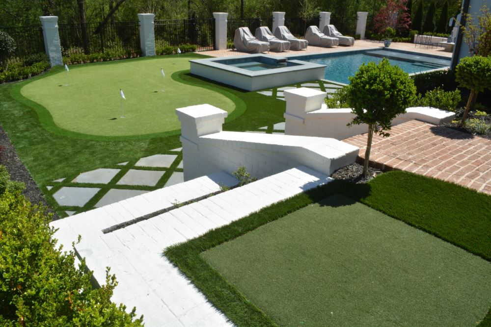 a putting green with tee line by a swimming pool